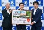 「明治日本の産業革命遺産」登録１０周年のＰＲポップを持つＪＴ鹿児島支社の吉窪伸哉支社長（右）ら＝２７日、県庁