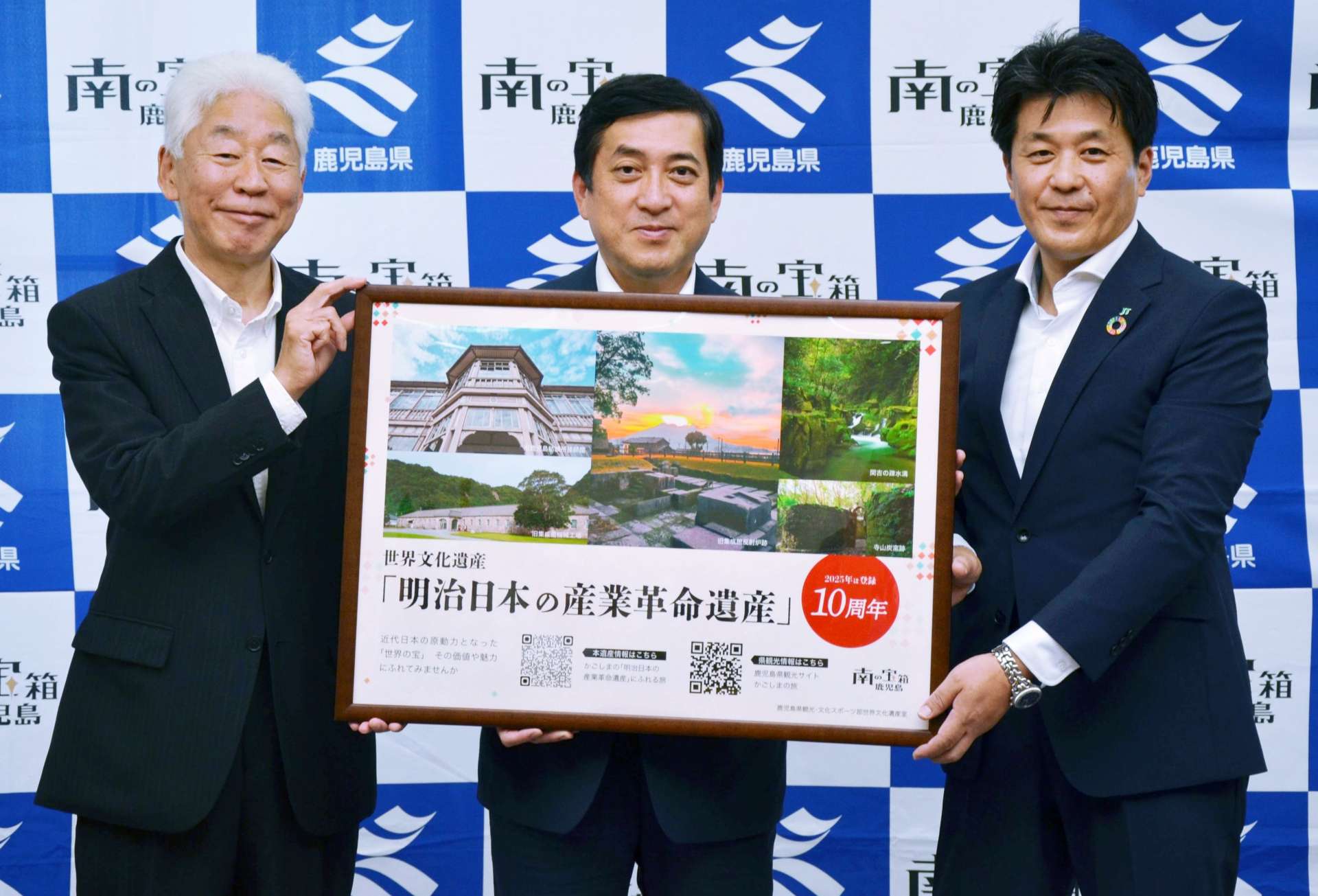 「明治日本の産業革命遺産」登録１０周年のＰＲポップを持つＪＴ鹿児島支社の吉窪伸哉支社長（右）ら＝２７日、県庁