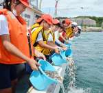 マダイの稚魚を放流する伊作田小学校の５、６年生＝日置市東市来の江口浜沖