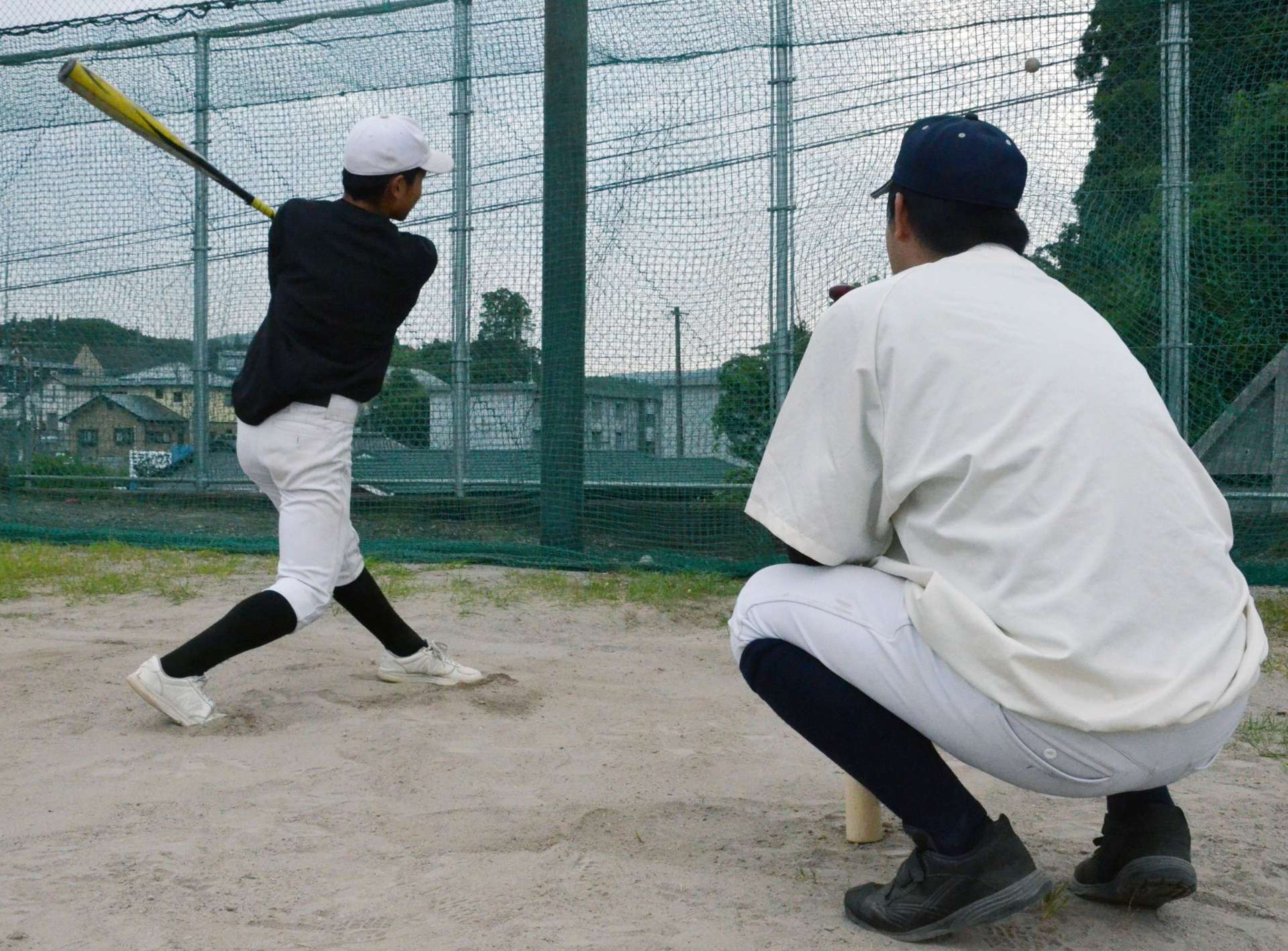 部活動終了後も個人練習に付き合う野球部顧問の教員＝６月６日