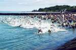 号砲とともに一斉に泳ぎ出す選手＝天城町与名間の与名間海浜公園