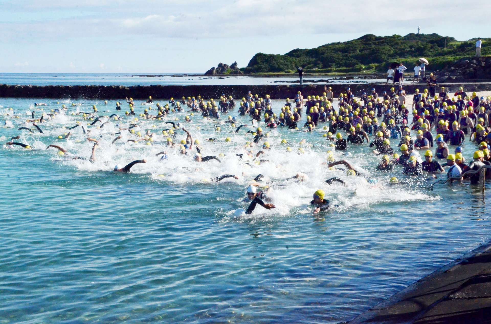 号砲とともに一斉に泳ぎ出す選手＝天城町与名間の与名間海浜公園