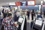 予定通り運航するか不安げに搭乗手続きに向かう乗客ら＝３日午後０時半、霧島市の鹿児島空港