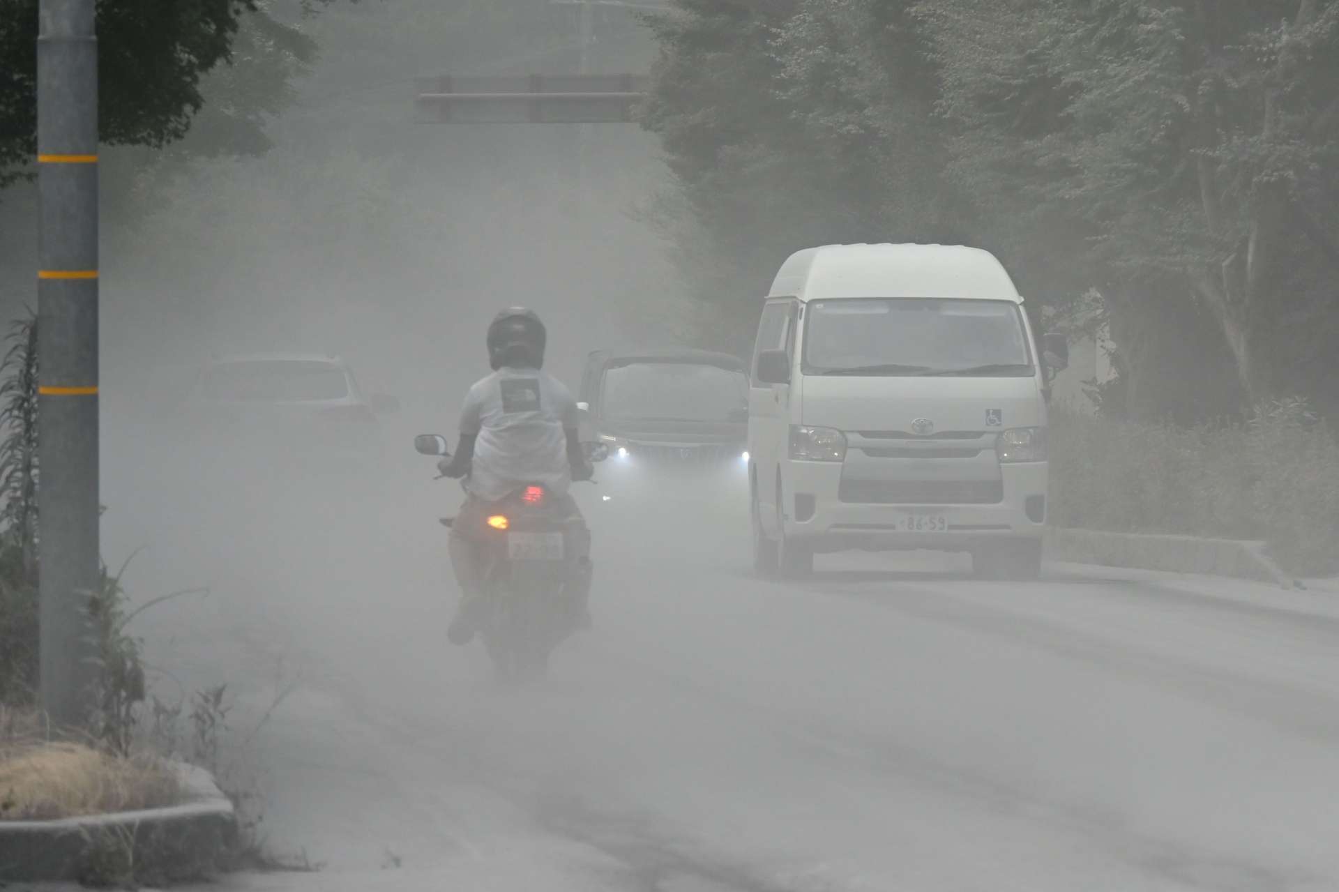 舞い上がった灰で見通しが悪くなった道路＝３日、霧島市牧園町高千穂