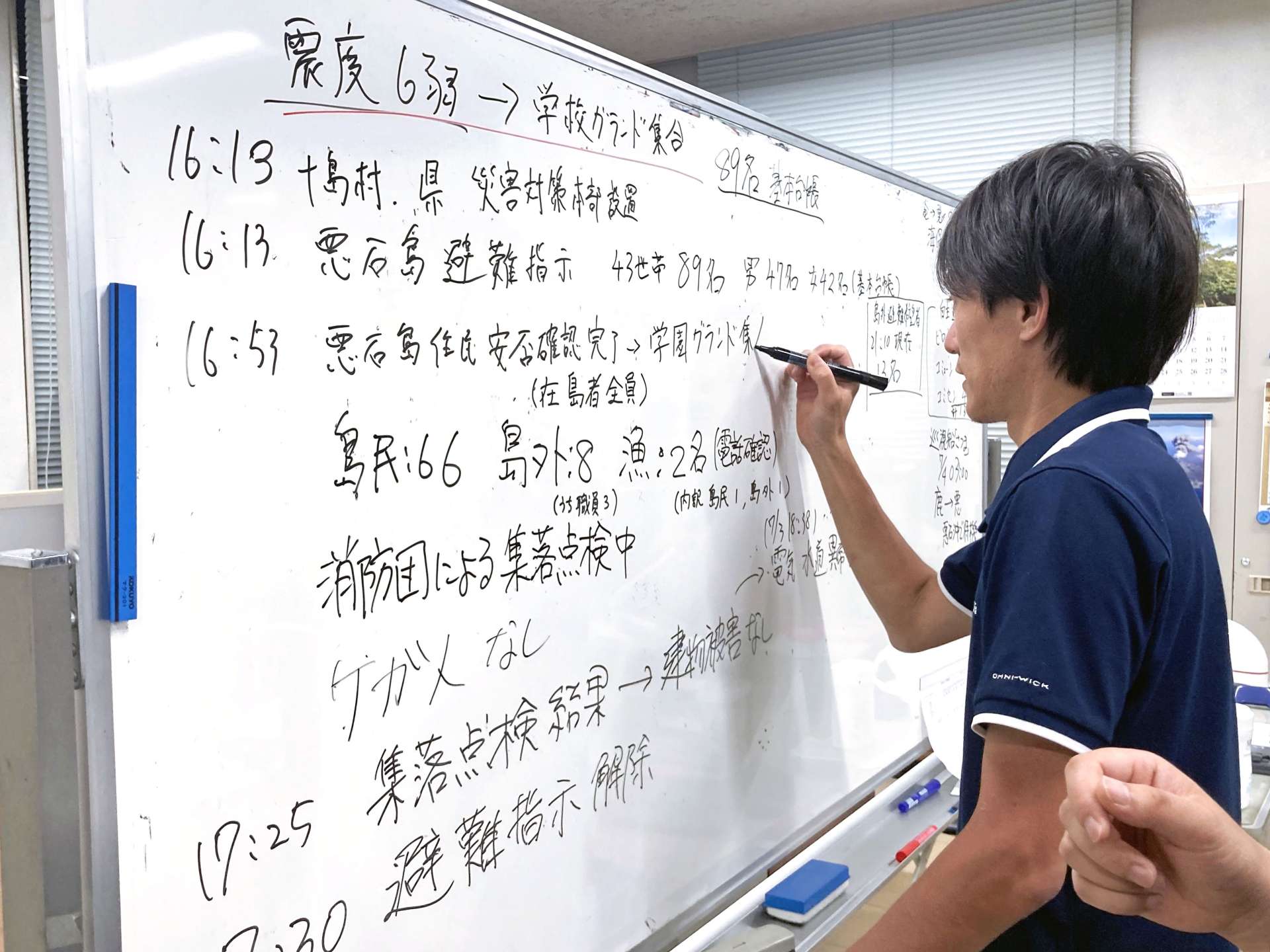 〈続々と入る情報〉ホワイトボードに書き込む十島村職員＝３日、鹿児島市の村役場