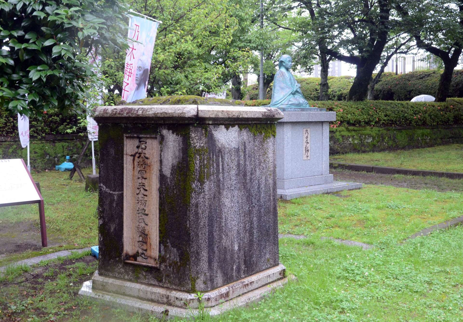 戦争中の金属回収で供出された乃木静子銅像の台座。隣には新しく造られた銅像がある＝鹿児島市新屋敷町