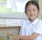 叔母が使っていた机を指さす中村海莉さん＝２日、指宿市の魚見小学校