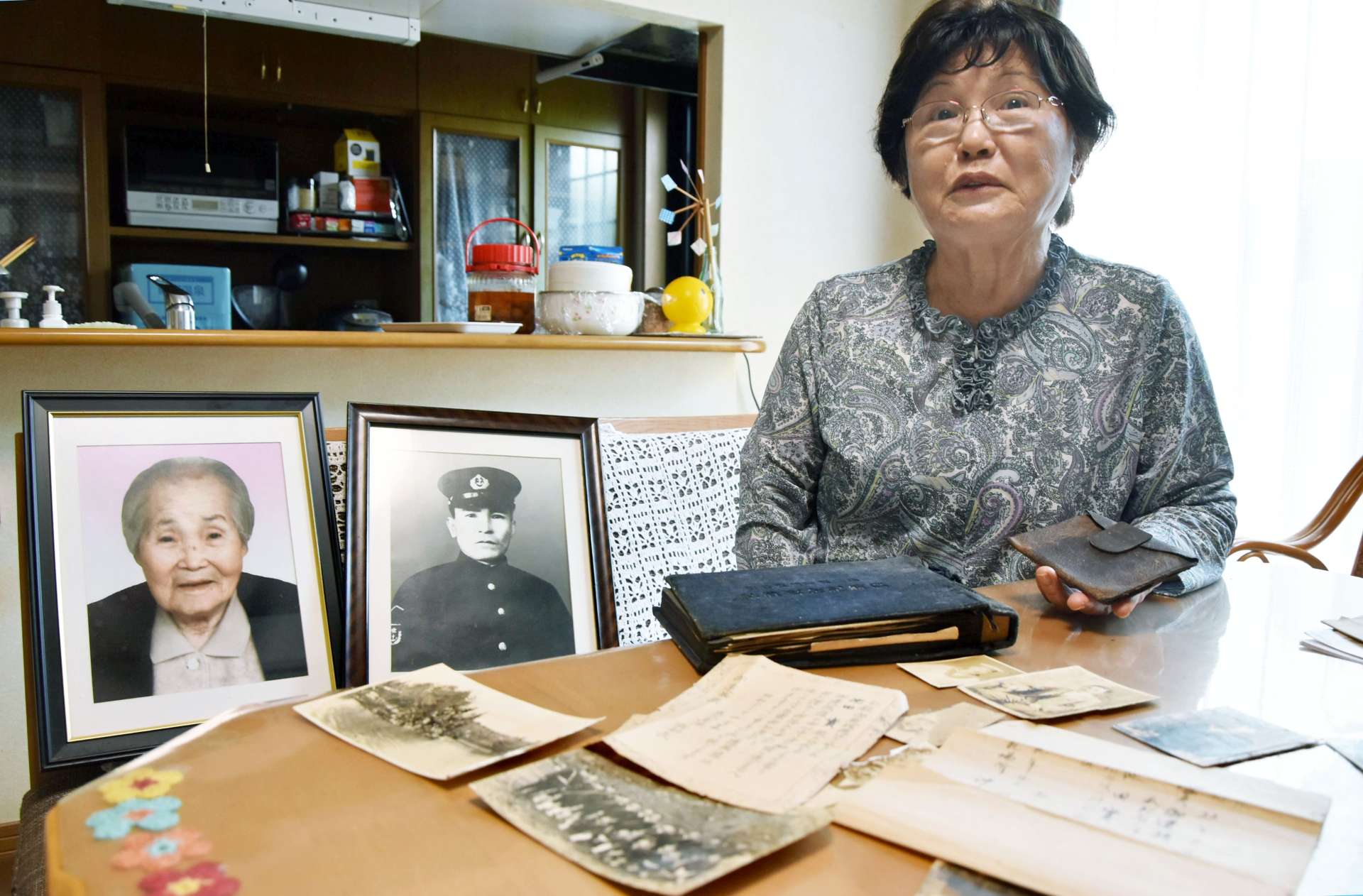 両親の遺影の前で母との思い出を話す池田ミキ子さん＝６月１７日、日置市吹上