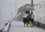 灰が降る中、一つの傘に入り下校する子どもたち＝３日午後３時半ごろ、霧島市牧園町高千穂