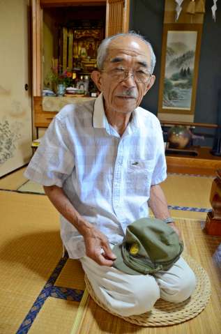陸戦隊時代の帽子を手に記憶をたどる白川節夫さん＝えびの市昌明寺