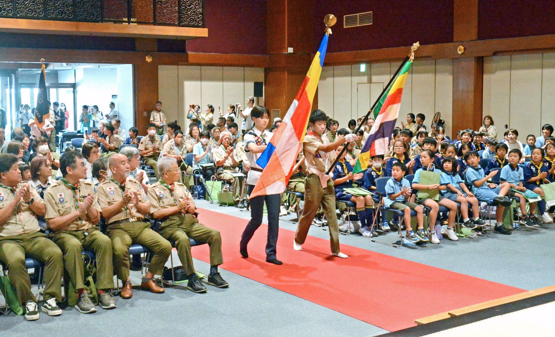 旗を掲げて入場するボーイスカウト鹿児島第２団とガールスカウト県第７団のメンバー＝鹿児島市西本願寺鹿児島別院