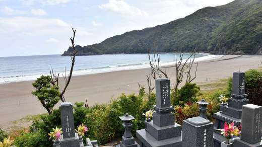 （護岸工事が中断していた嘉徳海岸）手前には集落の墓地が広がる