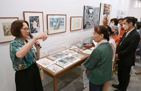 水木しげるさんの長女・原口尚子さんの解説を聞く来場者＝１０日、湧水町の霧島アートの森