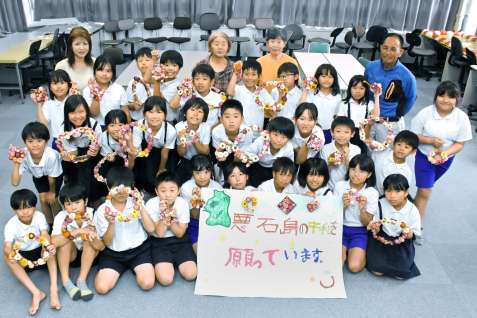 悪石島の子どもにリース飾りと横断幕を作った児童ら＝１０日、出水市の下水流小学校