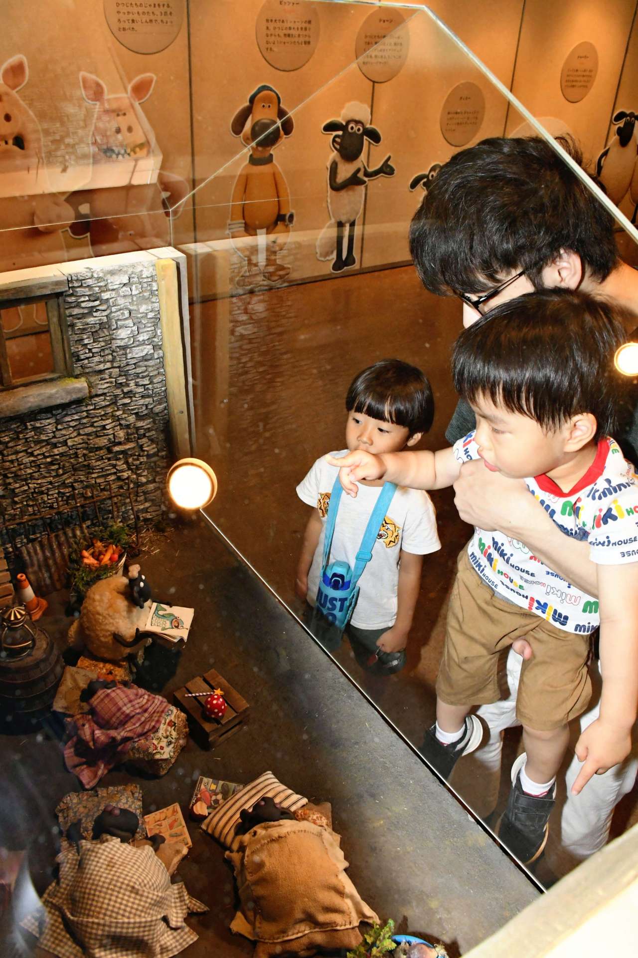 ジオラマに興味深そうに見入る来場者＝１２日、鹿児島市の黎明館