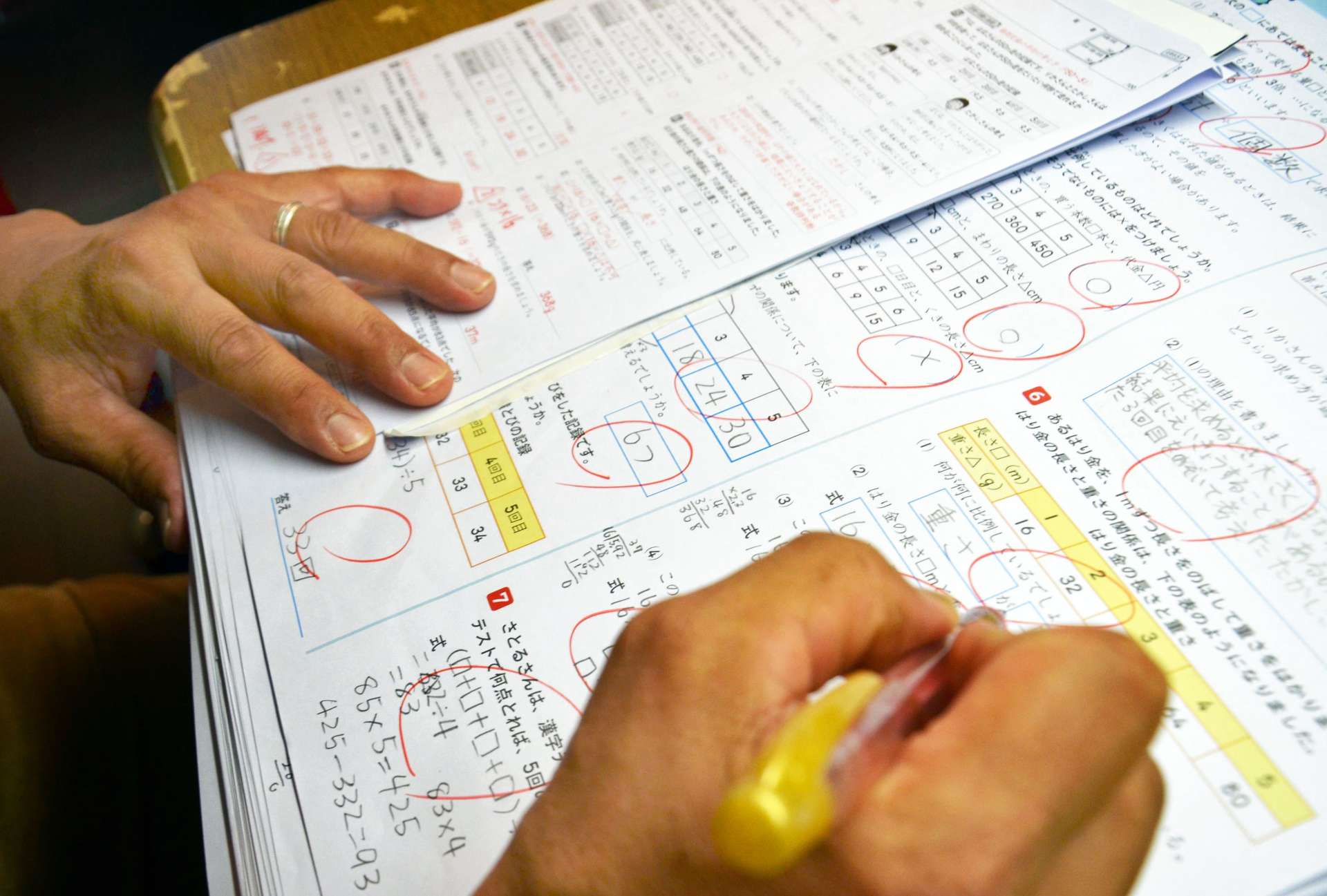 テストを採点する男性教諭。家に仕事を持ち帰るのは日常茶飯事という