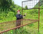 〈関連〉わなの点検をしながら笑顔を見せる外山千乃さん＝鹿児島市犬迫町