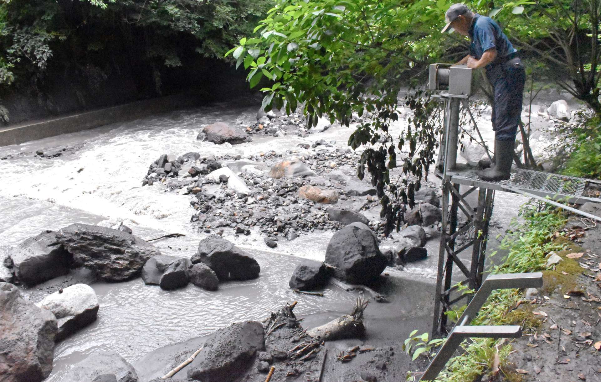 火山灰などでふさがれた取水口付近を確認する水利組合の関係者＝１２日、霧島市霧島田口の霧島川