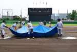 雨天順延が決まりグラウンドで作業をする選手ら＝１３日午前、鹿児島市の鴨池市民球場