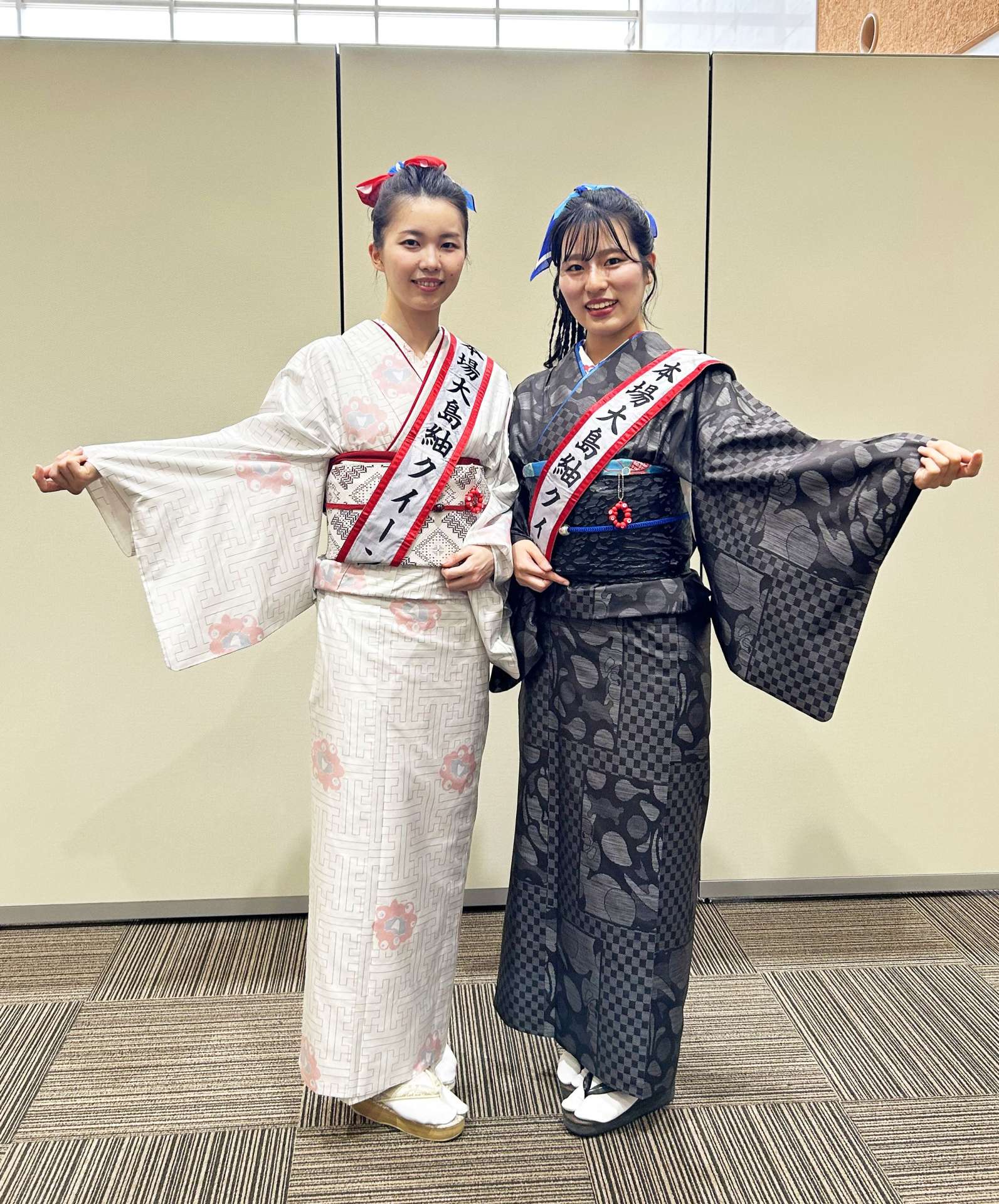 大阪・関西万博とコラボした大島紬を着用する今村果音さんと西原来海さん（左から）＝９日、南日本新聞社