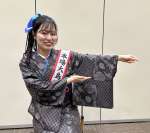 大島紬で表現した万博の公式デザイン「いのちの循環」を示す西原来海さん＝９日、南日本新聞社