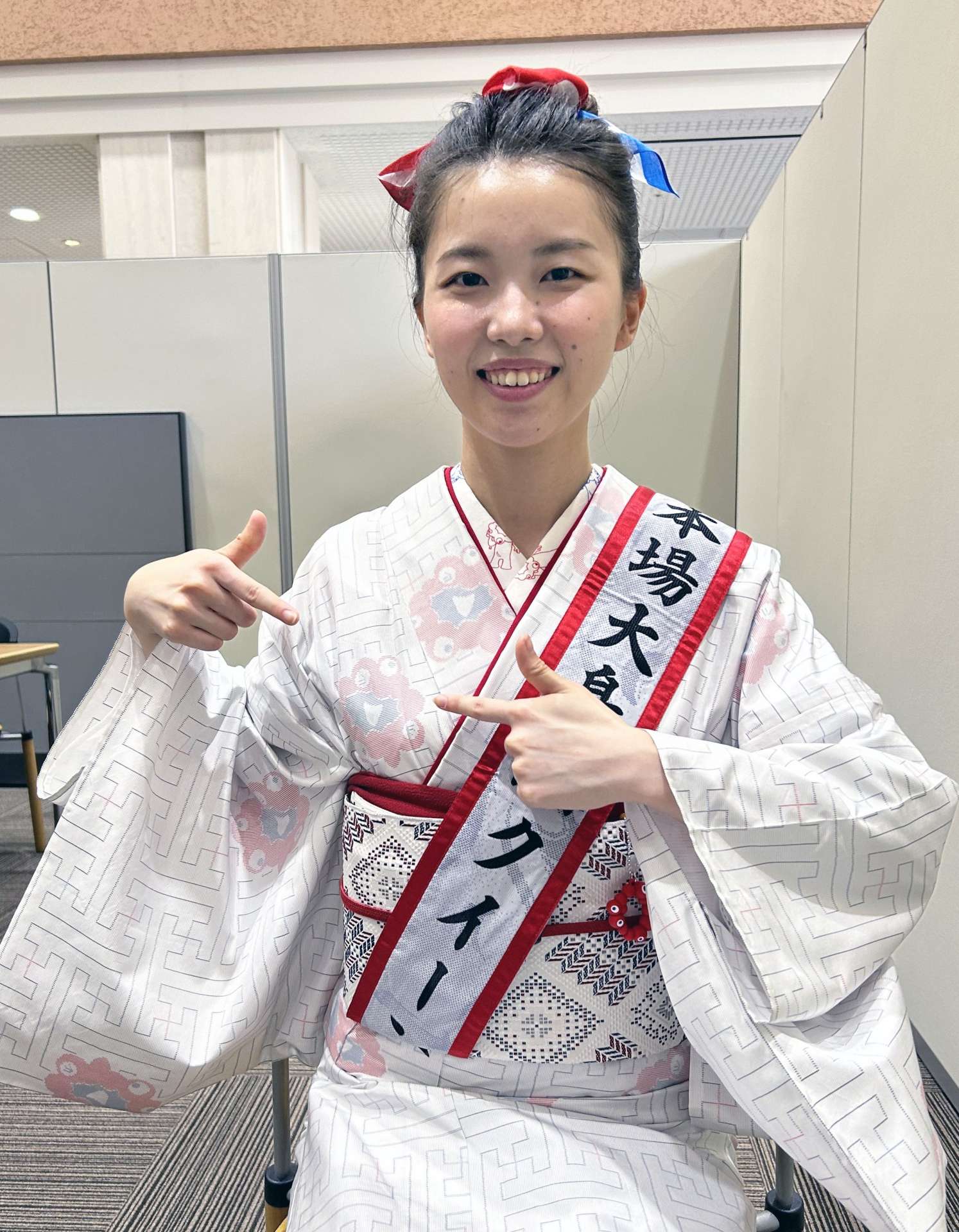 生地に描かれたミャクミャクを示す今村果音さん＝９日、南日本新聞社