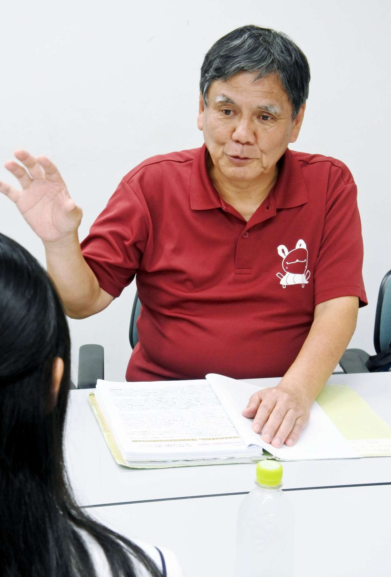 取材する高校生に、障害への理解を深める教育の重要性を説く茶圓亮一さん＝６月３０日、霧島市の国分公民館