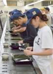 ２０２５年産二番茶を加工したてん茶の香りや手触りなどを確認する茶商ら＝１５日、鹿児島市の県茶市場