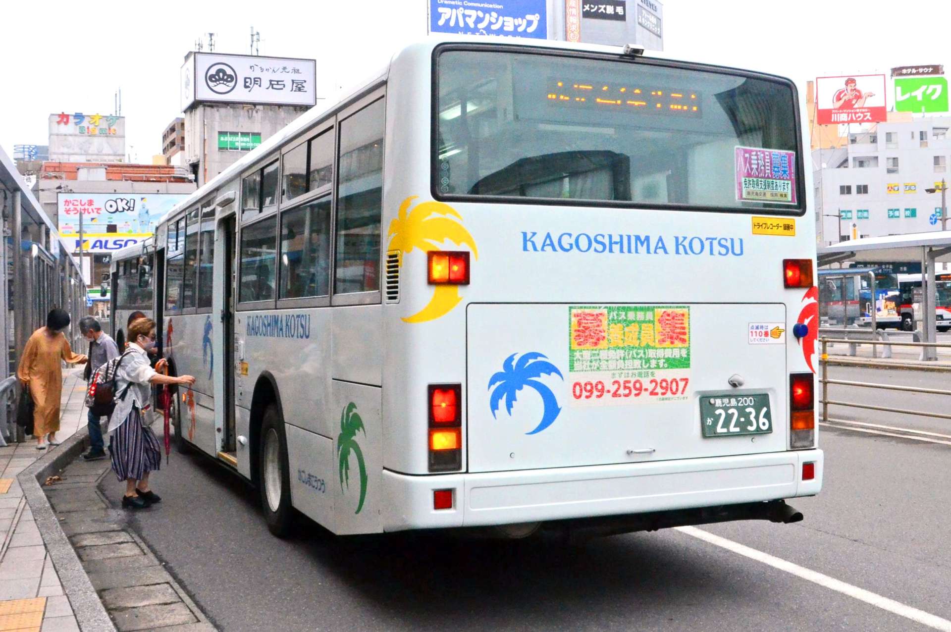 車体に運転手募集の広告を貼った路線バス。数年前から不足が続く＝１４日、鹿児島市のＪＲ鹿児島中央駅前