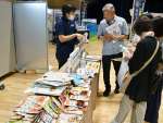 防災製品の説明を聞く来場者＝１６日、薩摩川内市のＳＳプラザせんだい