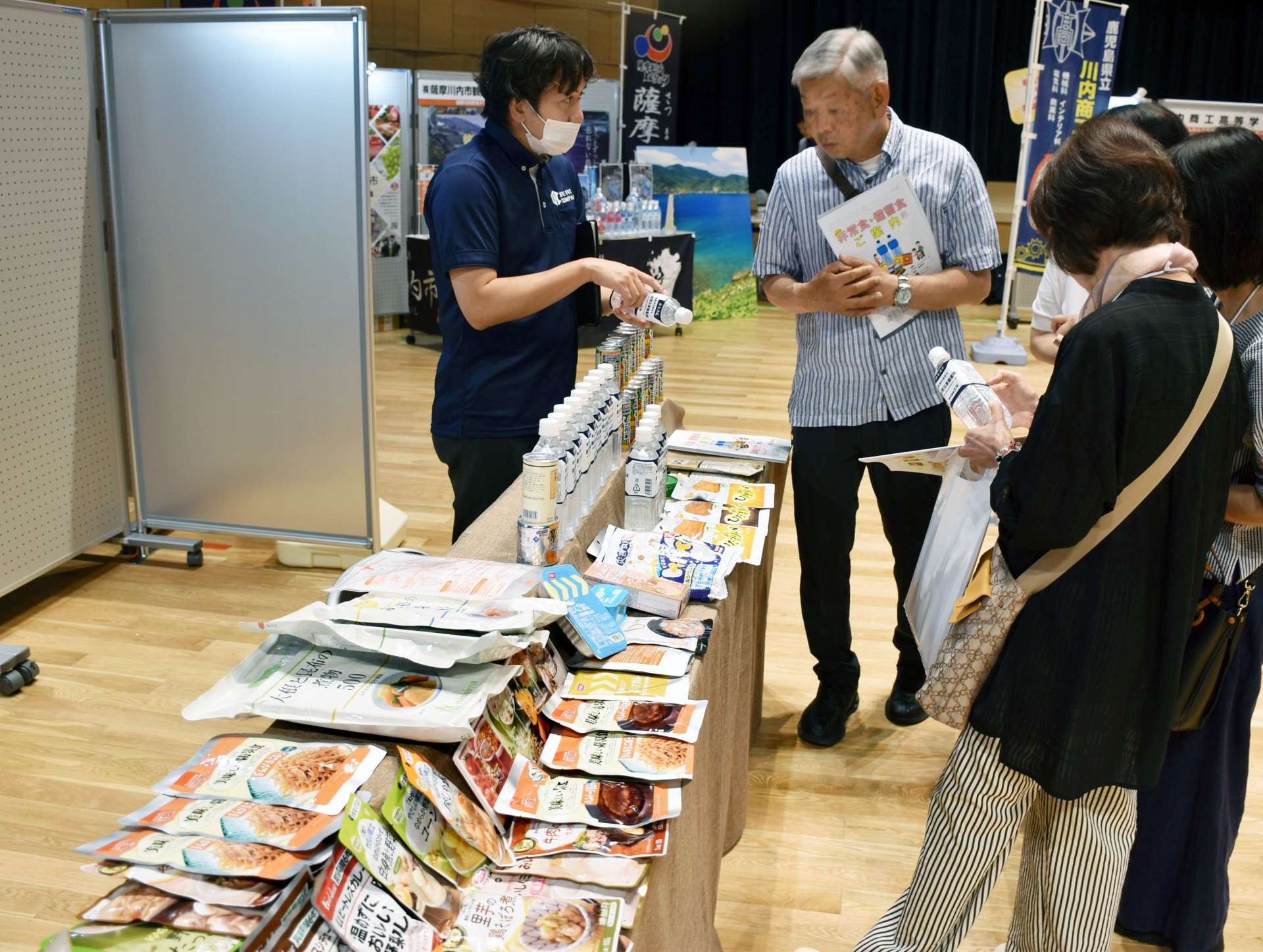 防災製品の説明を聞く来場者＝１６日、薩摩川内市のＳＳプラザせんだい