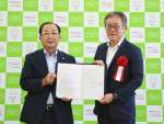 連携協定を締結した南九州市の塗木弘幸市長（左）とトヨタＰＣ鹿児島ホールディングスの中村博之社長＝１５日、南九州市役所