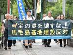 横断幕を持って裁判所に向かう原告ら＝１６日、宮崎市