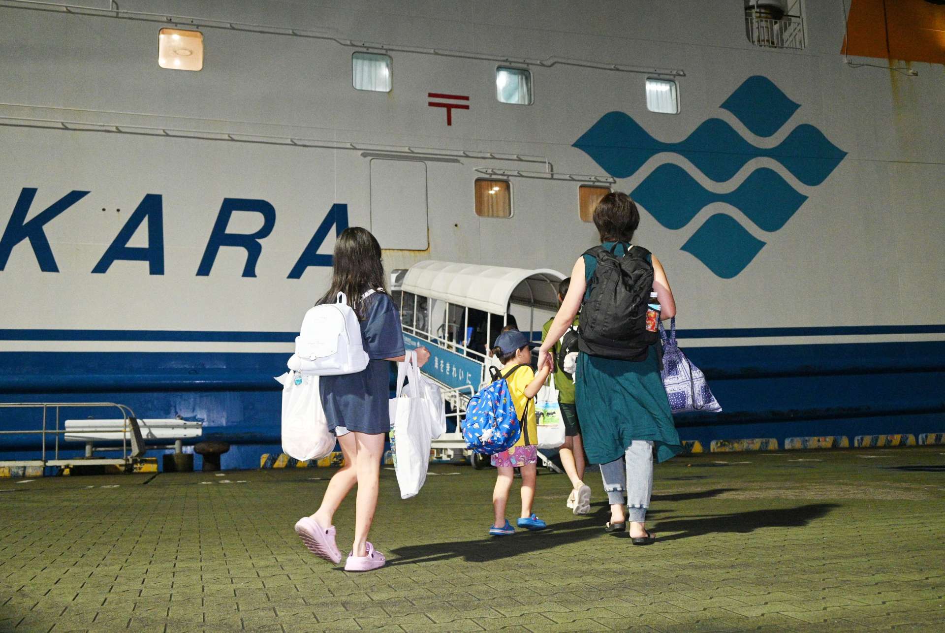 悪石島に帰るためフェリーに乗り込む住民＝１６日午後９時すぎ、鹿児島市本港新町の南ふ頭