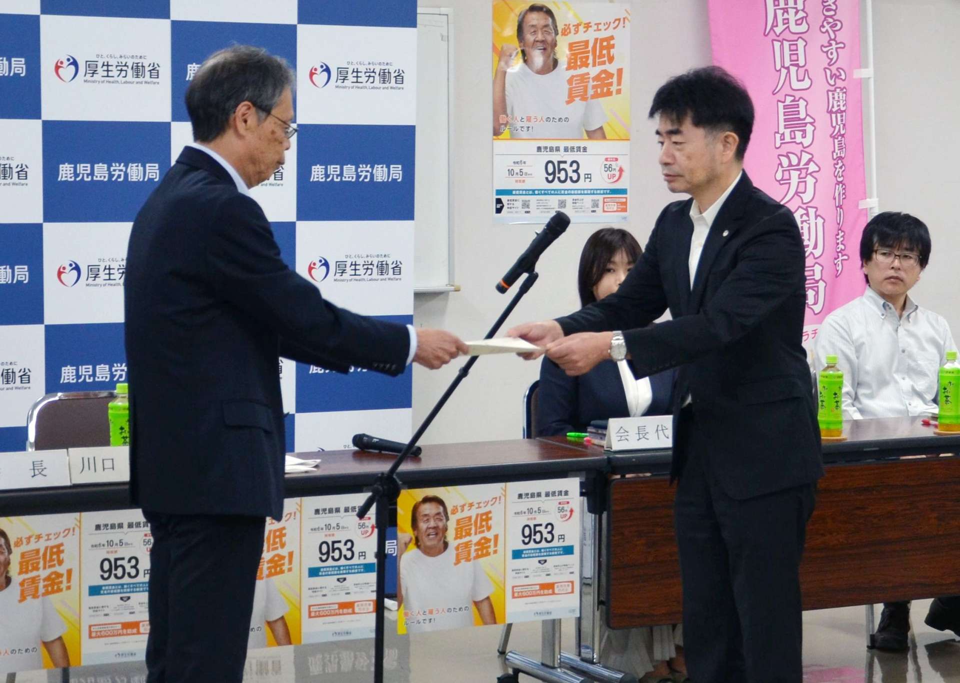 川口俊一会長（左）に最低賃金の改定を諮問する永野和則鹿児島労働局長＝１６日、鹿児島市山下町の鹿児島合同庁舎