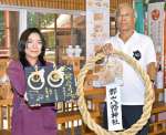 大阪・関西万博に展示し、郡山八幡神社に奉納された「輪守り」を持つ山下和弘氏子総代会長（右）と販売用を持つ和繼の井料明歩代表（左）＝伊佐市大口大田
