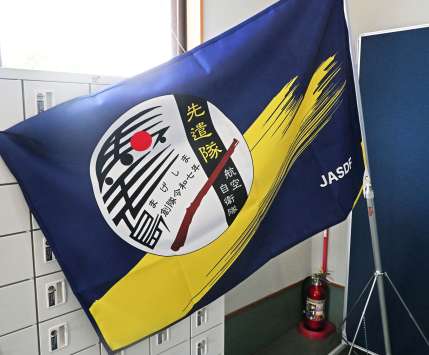 〈火縄銃がモチーフ〉馬毛島先遣隊のエンブレムが描かれた旗＝１７日、中種子町野間