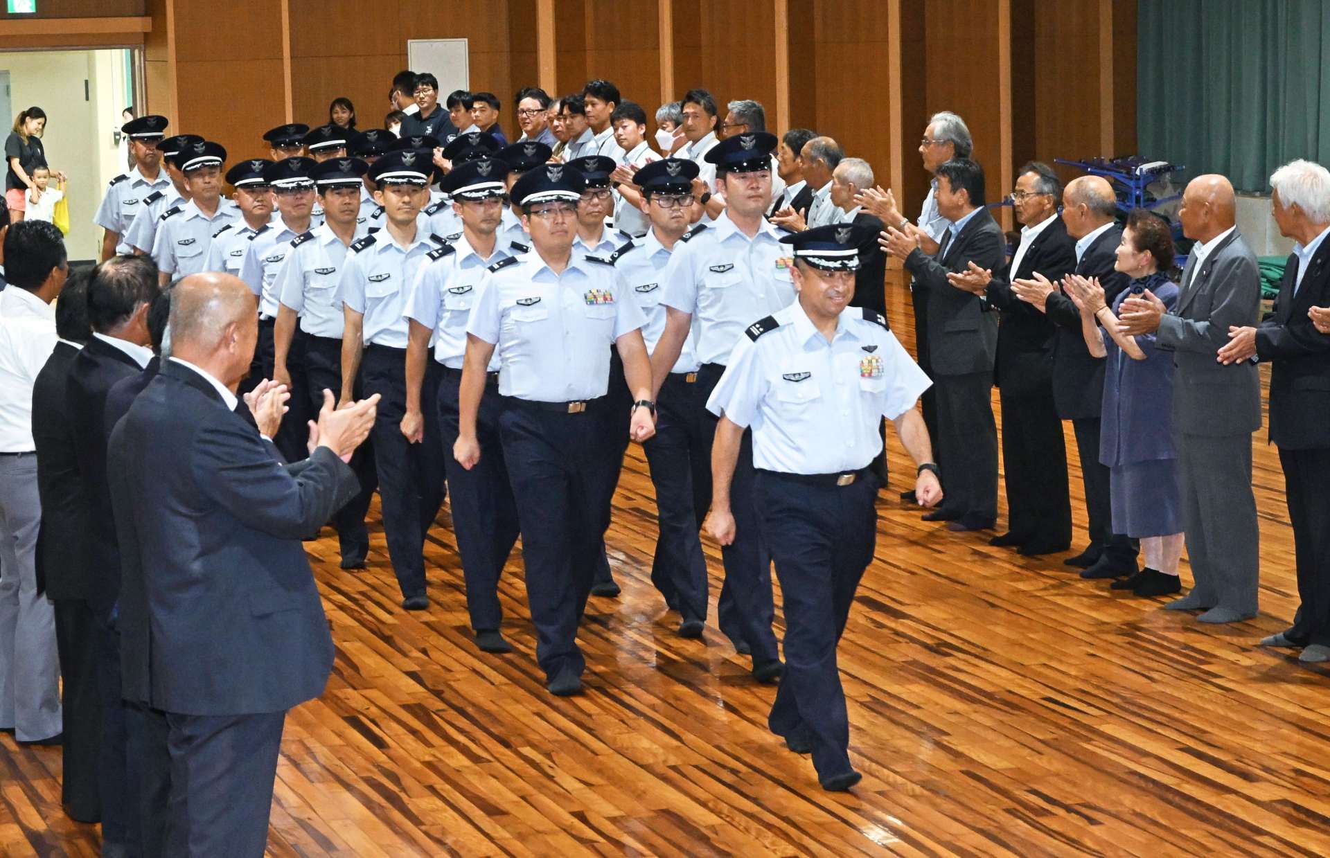 中種子町職員らの歓迎を受ける航空自衛隊馬毛島先遣隊＝１７日、同町立中央公民館
