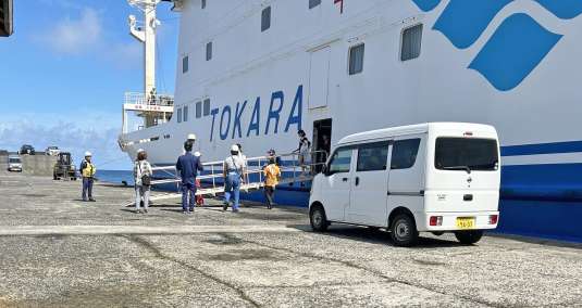〈避難先から帰島した住民ら〉＝１７日、十島村悪石島のやすら浜港（十島村提供）