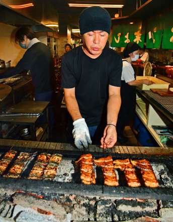炭火で香ばしく焼き上げられるうなぎ＝１８日午後、鹿児島市のうなぎの末よし