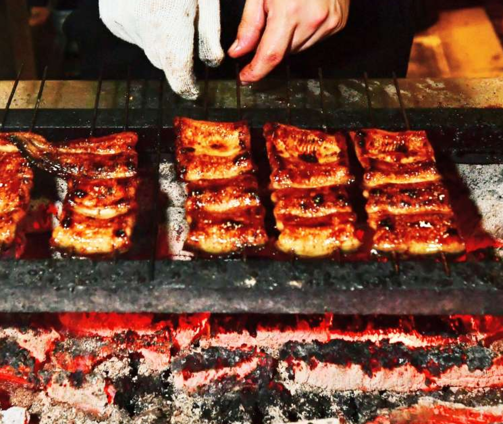 炭火で次々に香ばしく焼き上げられるうなぎ＝１８日午後、鹿児島市のうなぎの末よし