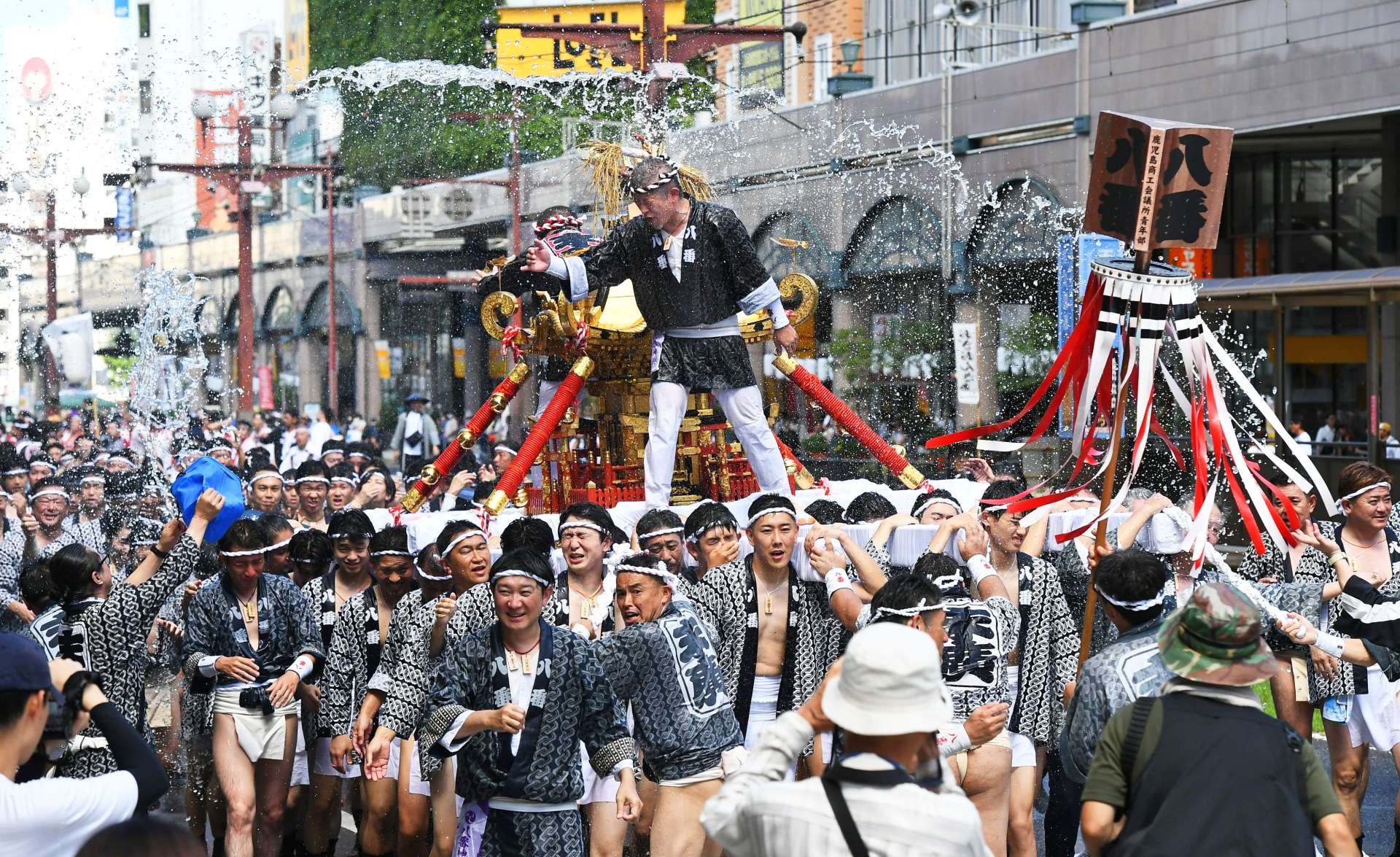 〈昨年の模様から〉力水を浴び、繁華街を勇壮に練り歩くみこし＝鹿児島市東千石町