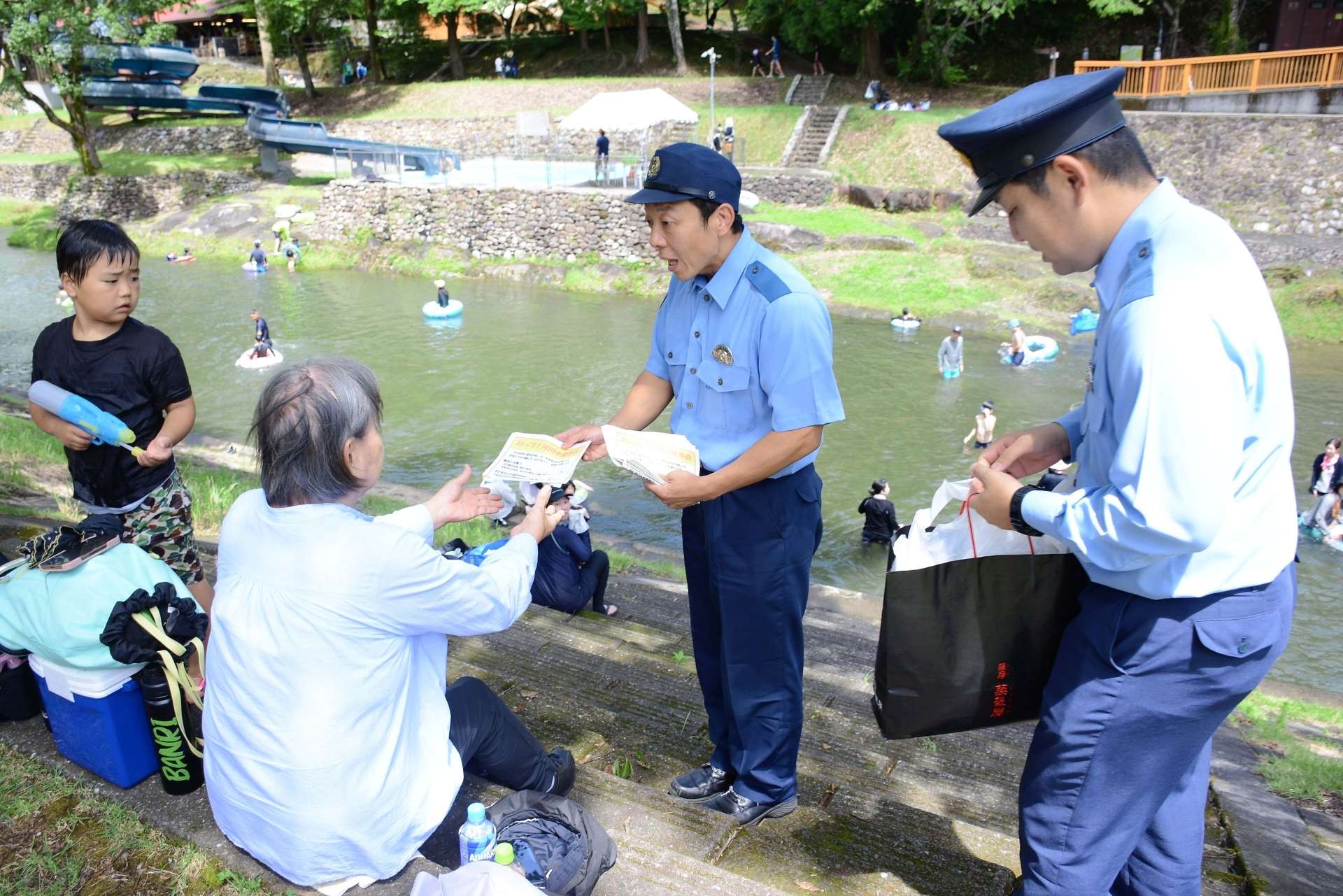 来園者にチラシを配り注意を呼びかける南九州署員＝１９日、南九州市川辺町清水