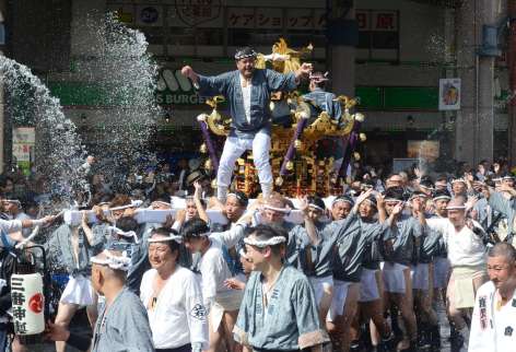 繁華街を力強い掛け声とともに練り歩くみこし＝２０日午後、鹿児島市の天文館