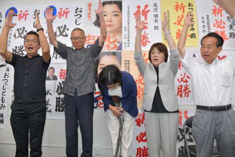 万歳三唱で深々と頭を下げる尾辻朋実さん（中央）＝２０日午後８時半、鹿児島市加治屋町