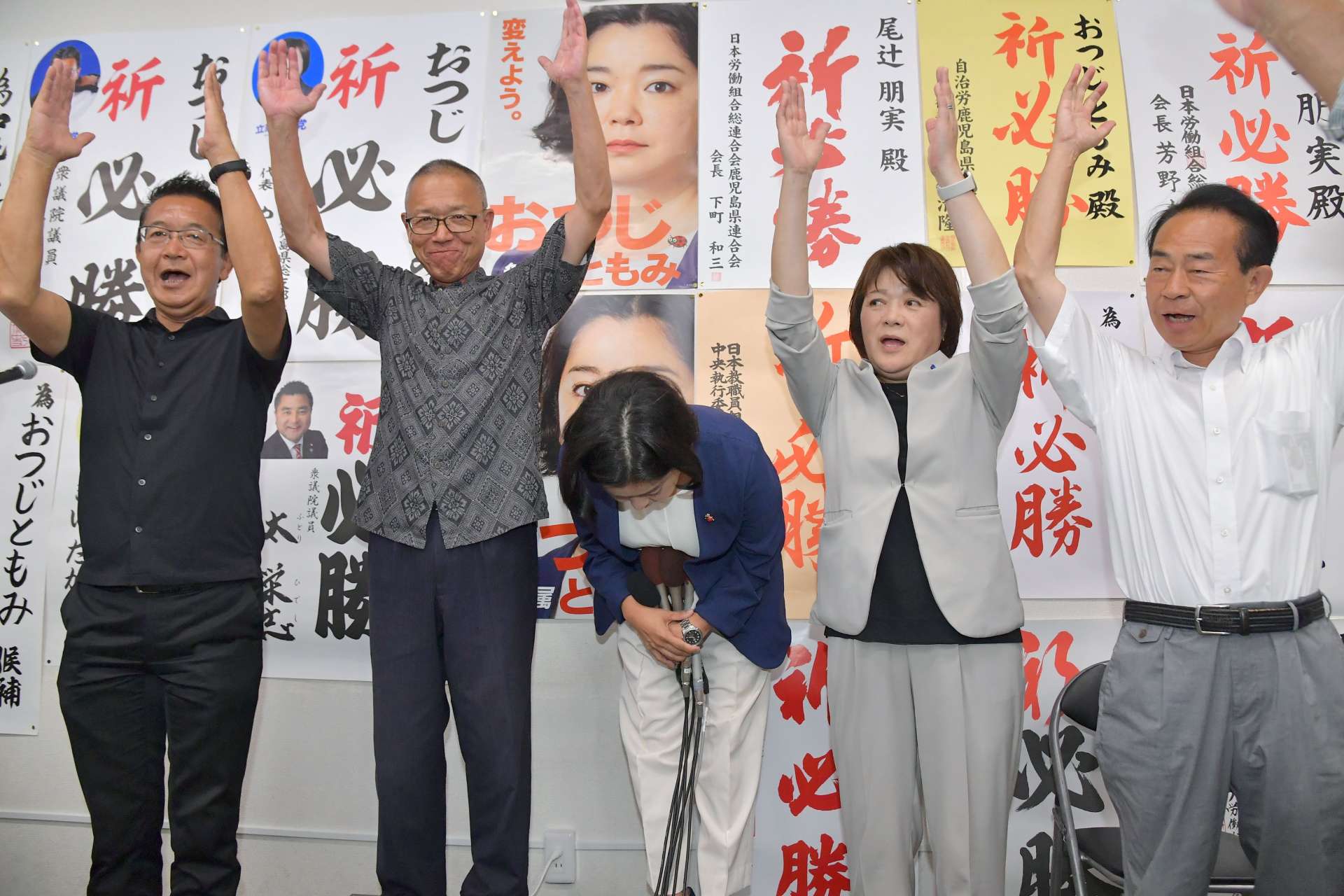 万歳三唱で深々と頭を下げる尾辻朋実さん（中央）＝２０日午後８時半、鹿児島市加治屋町