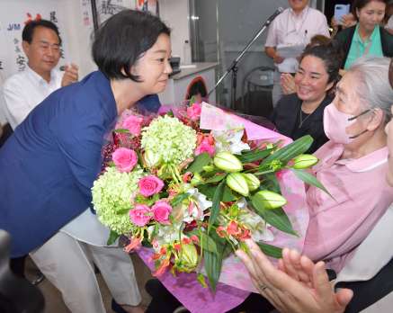 おばで元鹿児島県議会議員尾辻義さん（右）の祝福を受ける尾辻朋実さん＝２０日午後８時３０分、鹿児島市加治屋町