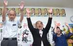 当選を喜び万歳する竹田正博さん（左）＝２０日午後１１時、曽於市末吉町二之方