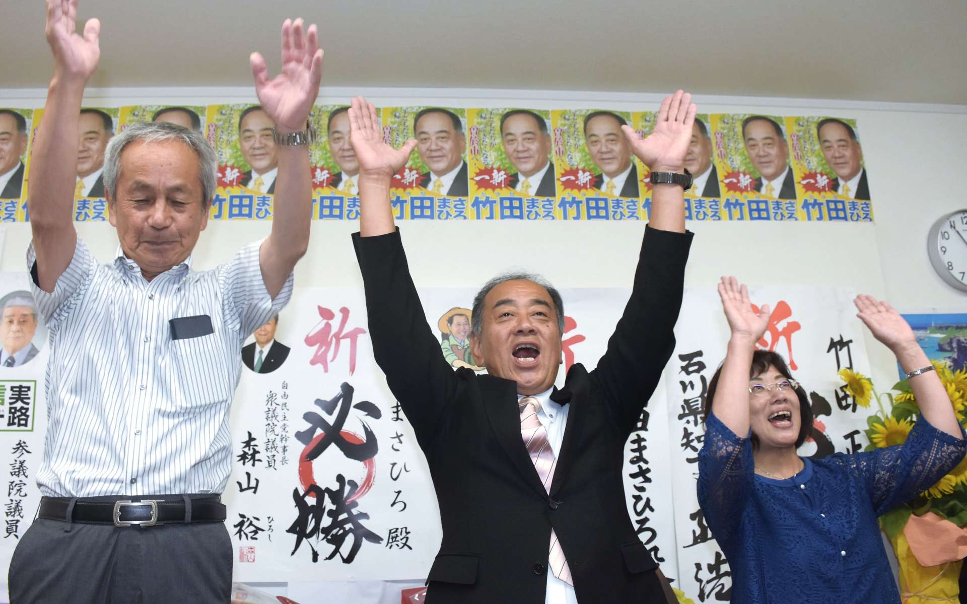 当選を喜び万歳する竹田正博さん（左）＝２０日午後１１時、曽於市末吉町二之方