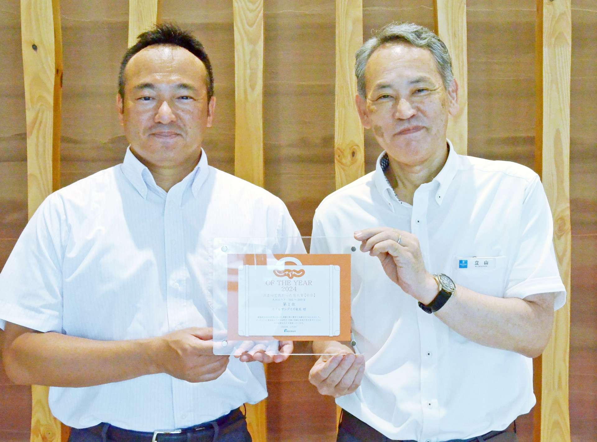 じゃらんアワードで入賞した竹山産業開発の竹山真之介代表取締役社長（左）＝奄美市名瀬